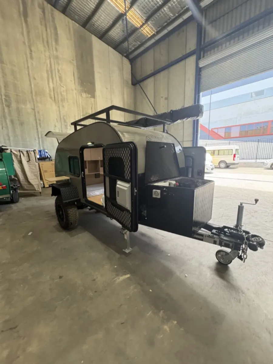 Breath Ultra in grey with tall roof rack, side door open and front toolbox, parked in a warehouse