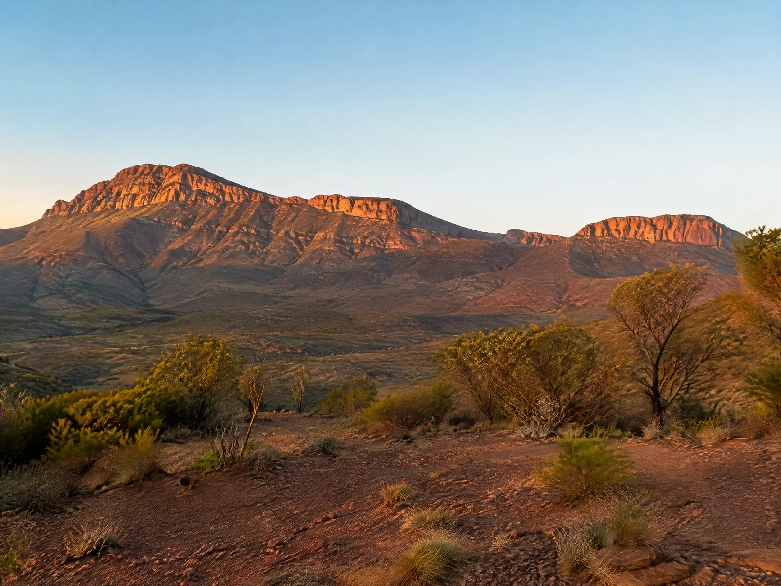 Wilpena Pound rock amphitheatre walls glowing orange at sunrise in the South Australian outback