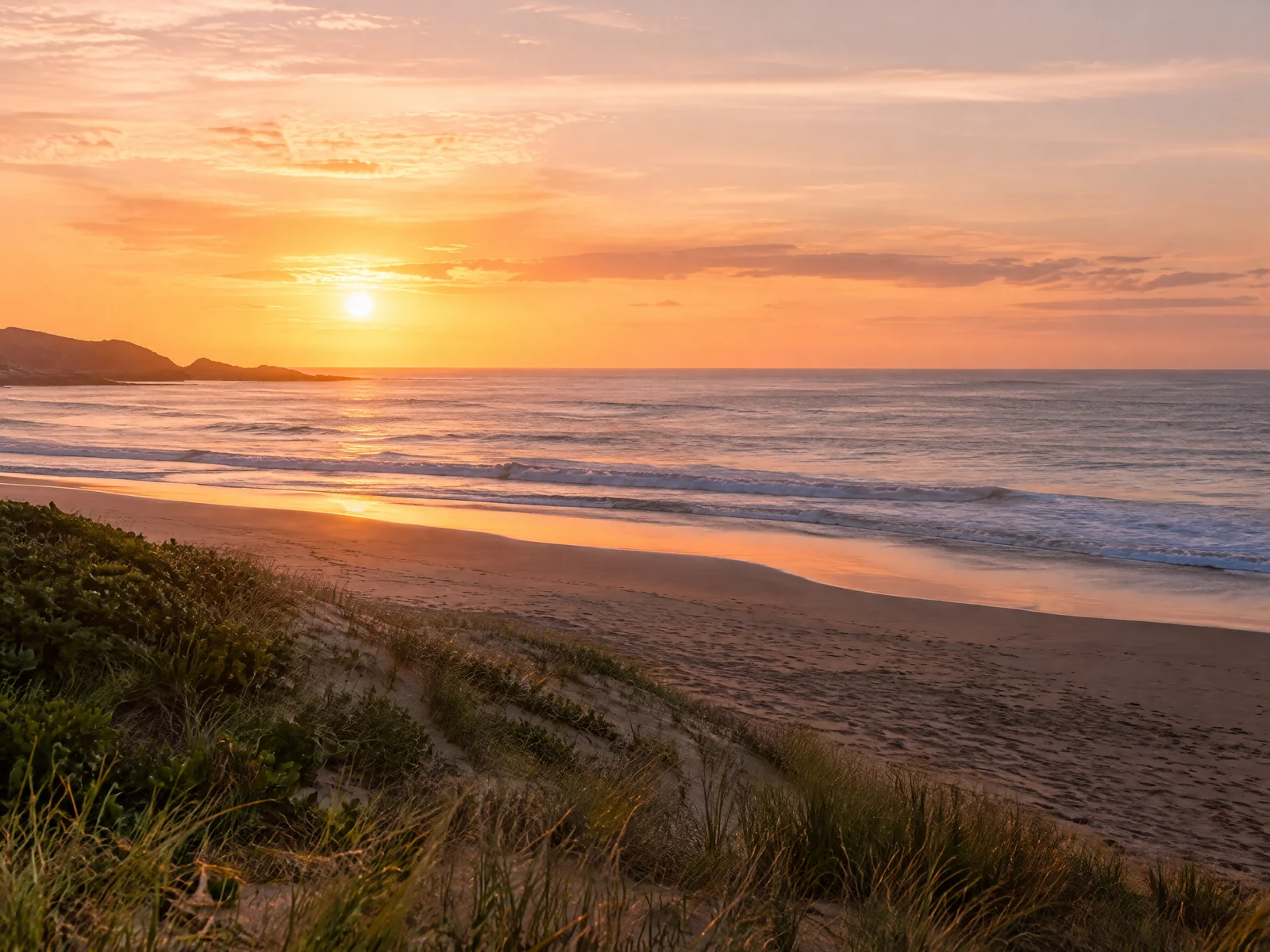Quiet Australian beach at sunrise on New Year's Day with pink and gold sky