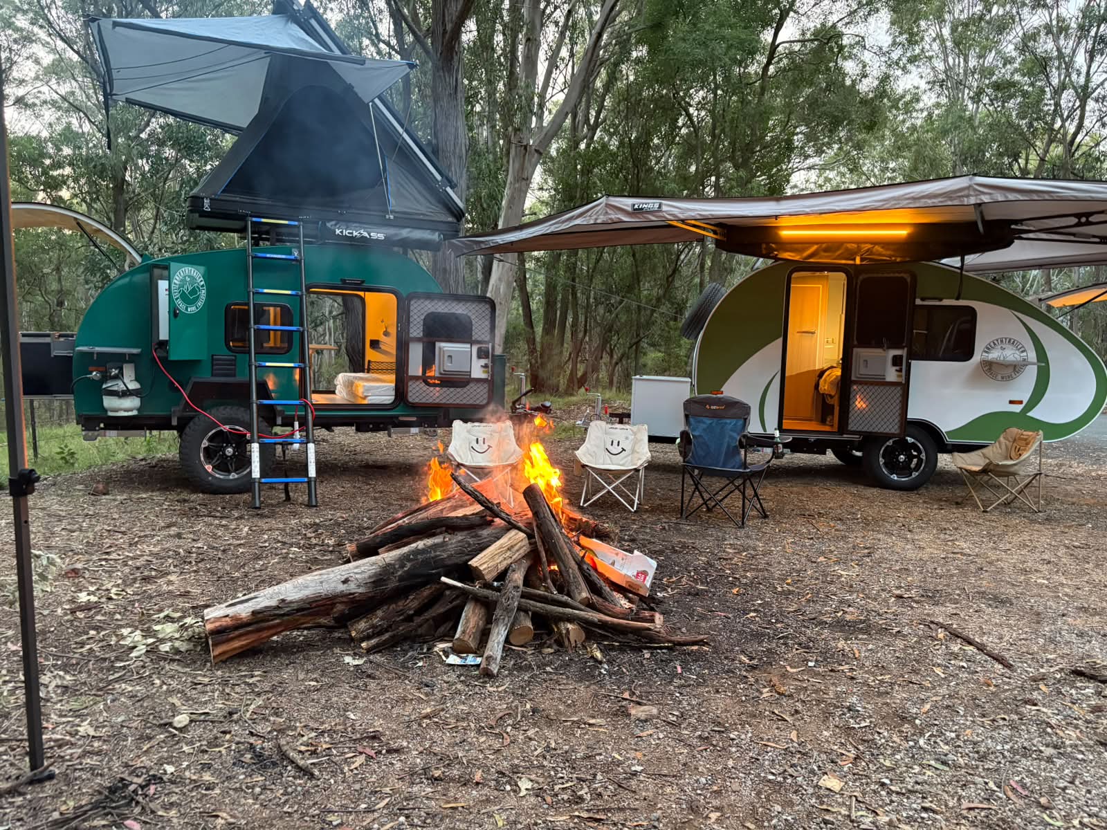 Breath Trailers around a glowing campfire with awnings open