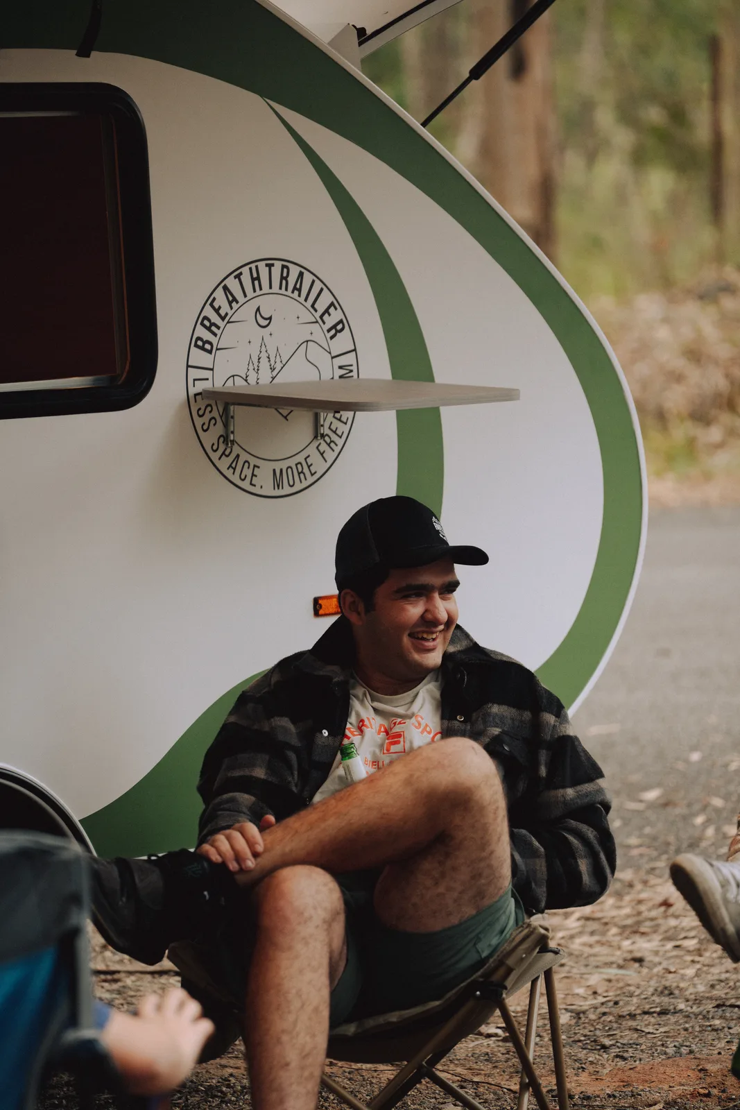 Breath Plus owner seated by the trailer branding