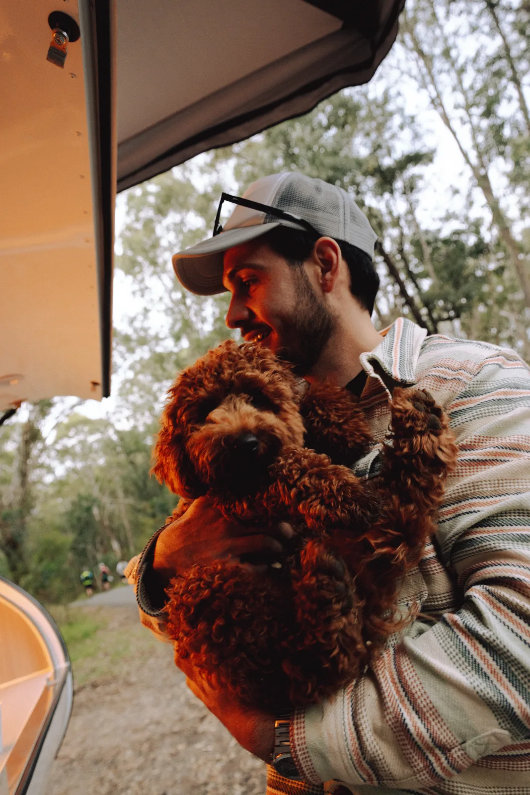 Breath Plus owner holding cockapoo by the trailer