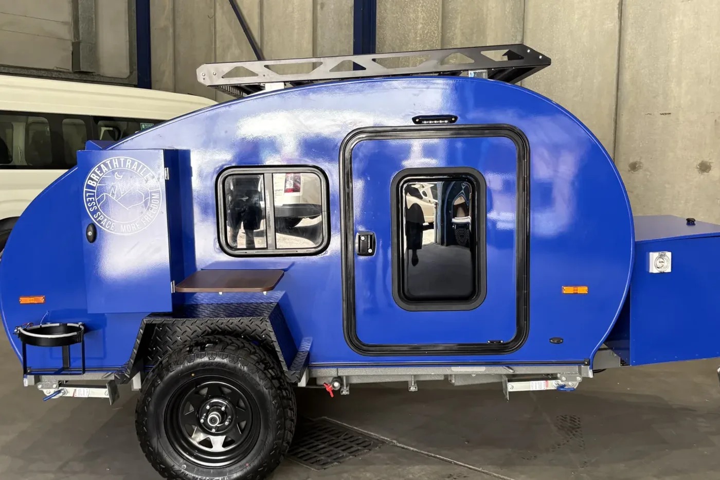 Breath Essential teardrop camper in blue, side view