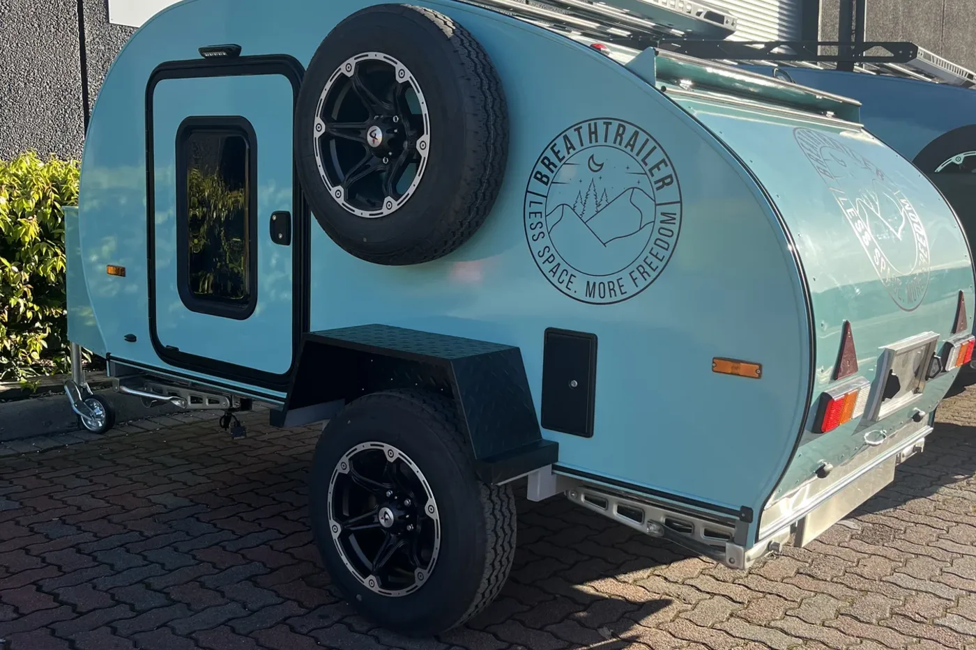 Breath Essential teardrop camper in teal with spare wheel