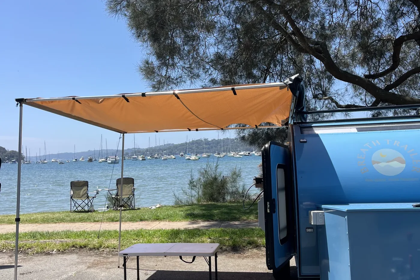 Breath Essential camped by the water with awning out