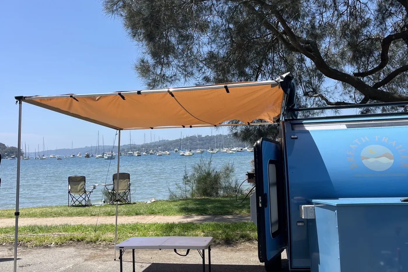 Awning, table and chairs set up beside the bay