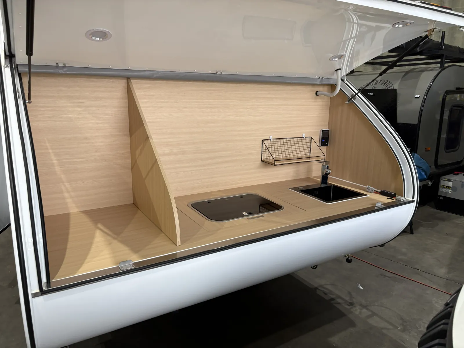Breath Max rear galley with hatch raised, glass-lidded cooktop, black sink and water heater control panel
