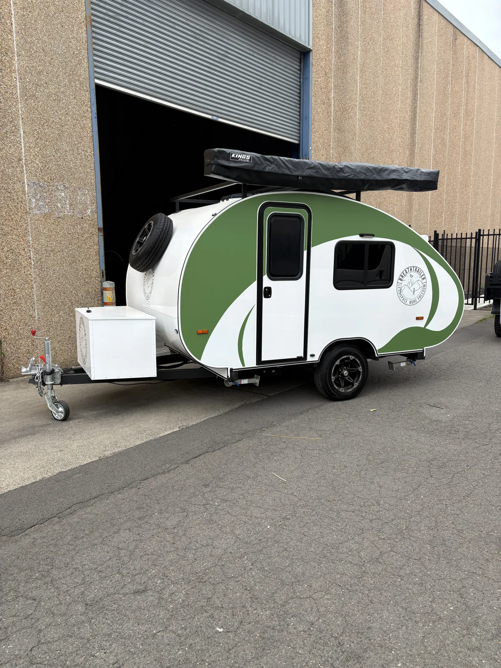 Breath Max in green and white with spare wheel, front toolbox and awning bag outside a warehouse