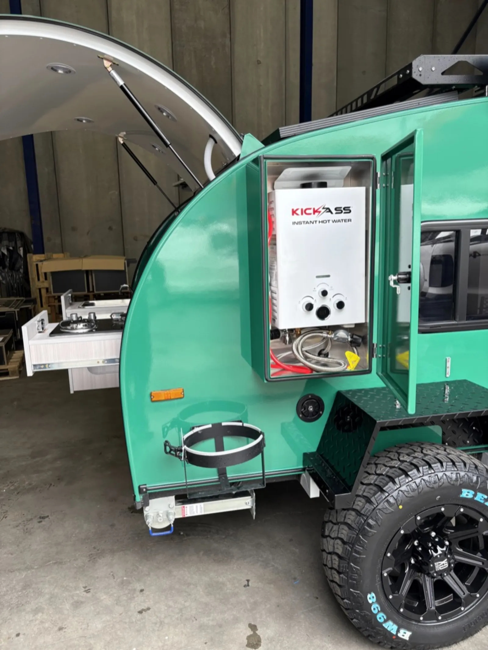 Breath Ultra side compartment open showing an instant gas hot water unit, with slide-out stove drawer behind