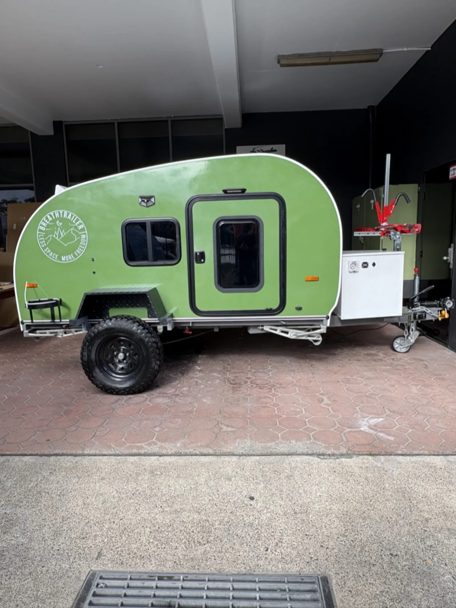 Breath Ultra in green, side profile, with front toolbox and bike carrier on the drawbar